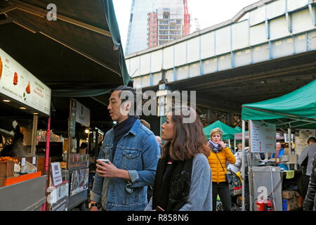 Un jeune couple l'extraction d'un food at Borough Market à Londres Angleterre Royaume-uni KATHY DEWITT Banque D'Images