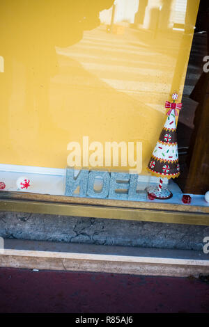 Quelques maigres décorations de Noël, avec un N inversé pour Noel dans une fenêtre de boulangerie à Montpellier, France Banque D'Images