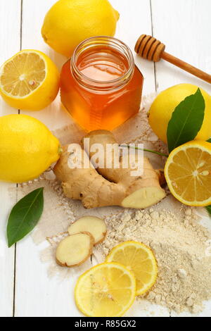 Racine de gingembre, citron et miel sur fond de bois blanc Banque D'Images