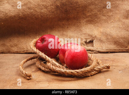 Pommes rouges sur la planche de bois et de toile de fond Banque D'Images