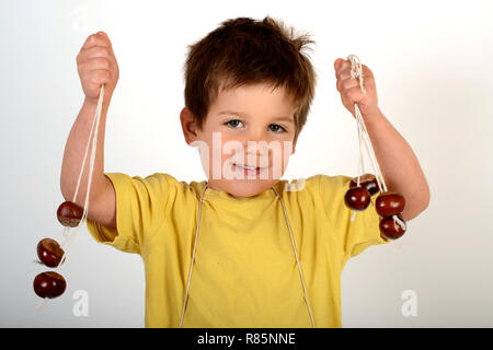 Jeune enfant garçon avec conkers Banque D'Images