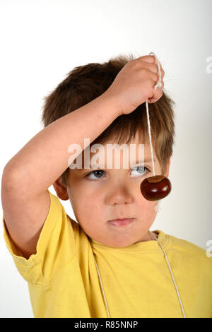 Jeune enfant garçon avec conkers Banque D'Images