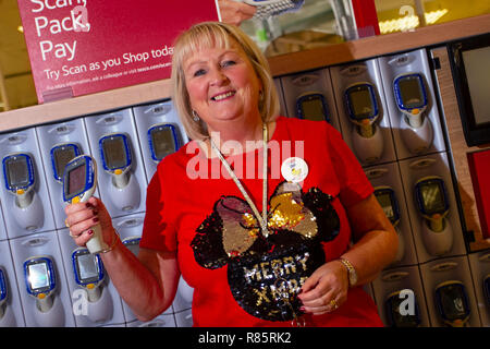 Southport, Merseyside, Royaume-Uni. 13 Décembre, 2018. Dorthy Mawdsley (MR) affiche l'esprit de Noël à Tesco en tant qu'employés Inscrivez-vous dans l'amusement de fête. Tesco employés entrés dans l'esprit de fête de Noël en soutenant l'organisation Save the Children's Christmas jumper jour. Membres du personnel ont accepté de m'en tenir sur un pull ridicule et encourager les dons pour aider à sauver la vie des enfants. Vendredi marque le septième jour cavalier de Noël annuel collecter des fonds pour la charité sur l'art vestimentaire de laine, l'événement de l'année MediaWorldImages AlamyLiveNews Crédit :/. Banque D'Images