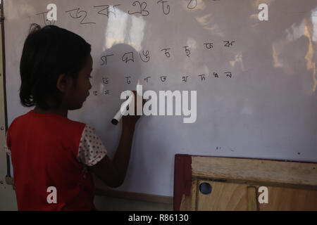 Dhaka, Bangladesh. 13 Décembre, 2018. Un enfant apprend dans une classe sur un bus à proximité de l'école qualité mobile Rarey Bazar, qui enseignent l'éducation primaire pour les pauvres des environs et les enfants des rues l'exploitation par l'ESPOIR 87 Foundation. Credit : MD Mehedi Hasan/ZUMA/Alamy Fil Live News Banque D'Images