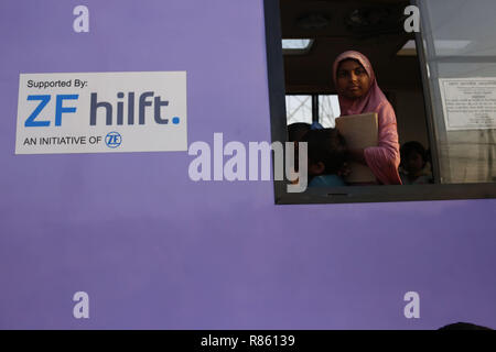 Dhaka, Bangladesh. 13 Décembre, 2018. Un enfant dans la fenêtre de l'autobus après la classe sur un bus près de l'école qualité mobile Rarey Bazar, qui enseignent l'éducation primaire pour les pauvres des environs et les enfants des rues l'exploitation par l'ESPOIR 87 Foundation. Credit : MD Mehedi Hasan/ZUMA/Alamy Fil Live News Banque D'Images