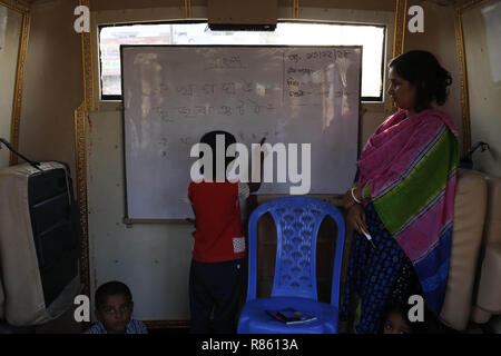 Dhaka, Bangladesh. 13 Décembre, 2018. Un enfant apprend dans une classe sur un bus à proximité de l'école qualité mobile Rarey Bazar, qui enseignent l'éducation primaire pour les pauvres des environs et les enfants des rues l'exploitation par l'ESPOIR 87 Foundation. Credit : MD Mehedi Hasan/ZUMA/Alamy Fil Live News Banque D'Images