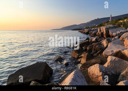 Coucher du soleil à la plage ci-dessous le phare de Trieste, Frioul-Vénétie Julienne, Italie Banque D'Images