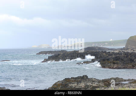 Les vagues se brisent sur les rochers de basalte de la côte en dessous des ruines du château de Dunsedick. Dunsedick, Comté D'Antrim, Irlande Du Nord, Royaume-Uni. Banque D'Images