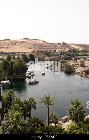 Bateaux égyptien sur le Nil, le désert occidental et mausolée de l'Aga Khan, vu depuis l'ère coloniale Britannique Old Cataract à Assouan, Egypte. Banque D'Images