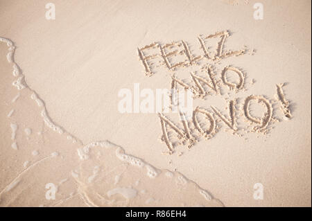 Feliz Ano Novo message (Bonne Année en portugais) à la main sur le sable doux de la plage de Copacabana à Rio de Janeiro, Brésil Banque D'Images