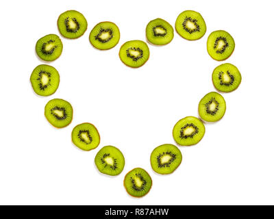 De fines tranches de kiwi en forme de coeur blanc sur fond texturé, pour motif. L'art abstrait composition de fruits frais biologiques isolated on white Banque D'Images