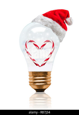 Snow globe Light bulb wearing Santa hat avec forme de coeur romantique Candy Cane et copiez l'espace. Saison de Noël brillant et lumineux Nouvelle Année. Banque D'Images