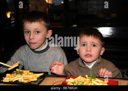 Boy eating French Fries dans un café de la rue Banque D'Images