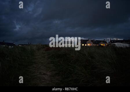 Terrasse maisons et chalets dans la nuit dans le village balnéaire de conseil informatique, Anglesey, au nord du Pays de Galles, Royaume-Uni Banque D'Images