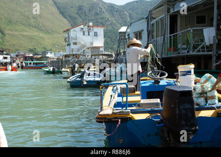 Tai O, village de pêcheurs de l'île de Lantau, Hong Kong, Chine. 27 Oct 2018 : Fisherman holding filet de pêche sur le bateau dans l'eau à l'intérieur de Tai O village de pêcheurs. Banque D'Images