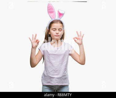 Belle jeune fille portant des oreilles de lapin de Pâques sur fond isolé vous détendre et souriant avec les yeux fermé faisant le geste de la méditation avec les doigts. Le Yoga Banque D'Images