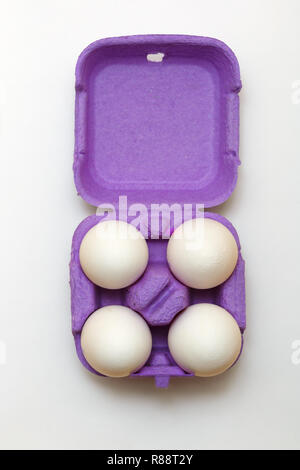 Composition de Pâques. Ensemble de quatre œufs blancs en violet sur fond blanc Banque D'Images
