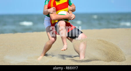 Jouer au rugby sur la plage. Sport d'équipe Banque D'Images