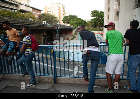 Les jeunes hommes appuyé contre une clôture en ville, Caracas, Venezuela, Amérique du Sud Banque D'Images