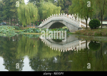 Pont et arbres environnant reflète dans l'eau dans le lac de l'Est, Shanghai, Chine. Réflexion sur l'eau cristalline de pont et arbres environnants. Banque D'Images