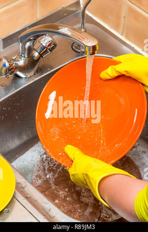 Laver les mains des femmes une assiette dans l'évier, sous l'eau Banque D'Images