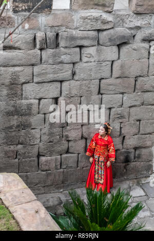 Femme en robe rouge - femme chinoise en costume traditionnel posing in Chongquing près du mur du port. Banque D'Images