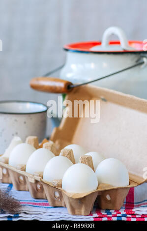 Des œufs frais dans un récipient de papier et le lait dans un bidon sur un fond de bois. La vie encore. Style rustique. Banque D'Images