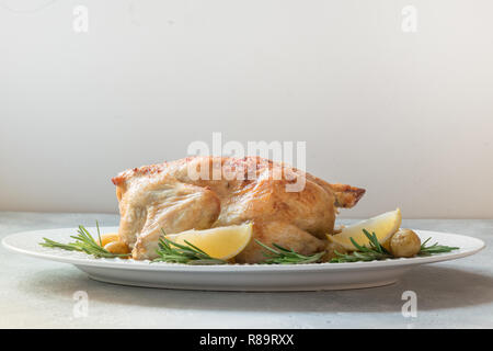 Poulet rôti aux pommes et au romarin sur tableau blanc. Copier l'espace. Banque D'Images