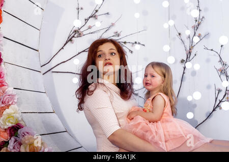 Jeune Femme Assise Avec Sa Fille Pleurer Bouleversee Bebe Fille En Larmes En Robe Rose Photo Stock Alamy