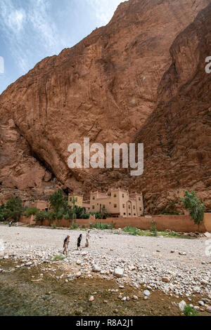 Un groupe de femmes devant un petit groupe de bâtiments niché au pied de la Gorges de Todra, Tinghir, Maroc Banque D'Images