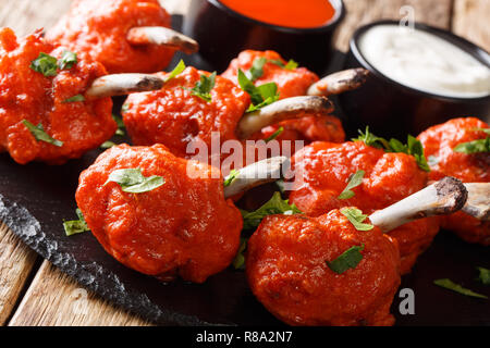 Recette de sucettes fried chicken wings avec des sauces close-up sur une liste de sélection sur une table de bois horizontal. Banque D'Images