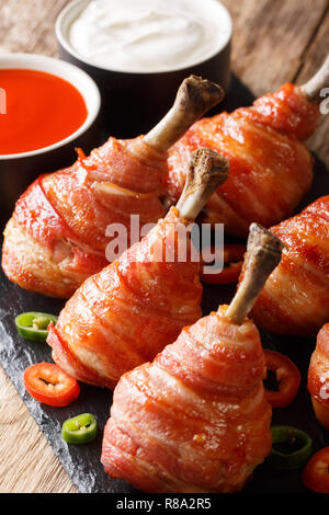 Sucettes de poulet bacon avec des sauces sur la table verticale. Banque D'Images
