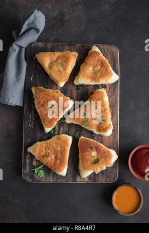 Pâtés de viande frits, samsa, samosas, echpochmak - viandes traditionnelles tartes farcis végétariens ou pâtés sur fond rustique, copiez l'espace. Banque D'Images