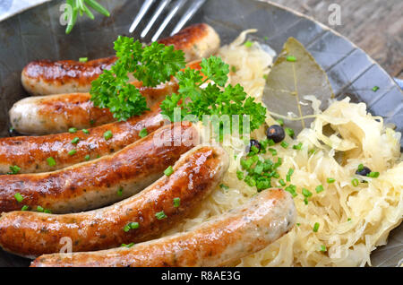 Saucisses bavaroises savoureuses de Nuremberg, servi sur la choucroute dans une poêle de fer Banque D'Images