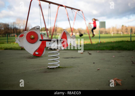 Aire de jeux pour enfants avec le poisson en bois sur un ressort et faire basculer en arrière-plan Banque D'Images