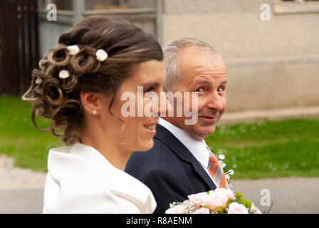 Mariage slovaque caucasian male marcher aux côtés de la jeune femme en robe de mariage avec le mariage bouquet dans ses mains. Banque D'Images