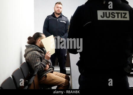 Stuttgart, Allemagne. 14 Décembre, 2018. Un défendeur contient le papier en face de son visage avant le début du procès dans la salle d'audience de la Haute cour régionale. Il est accusé d'avoir été impliqué de façon significative dans l'enlèvement d'un employé de l'ONU en Syrie en 2013. (Pour 'enlèvement d'un dpa-employés - Émissions fugitives des menace de mort' du 14.12.2018) Crédit : Simon Sachseder/dpa/Alamy Live News Banque D'Images