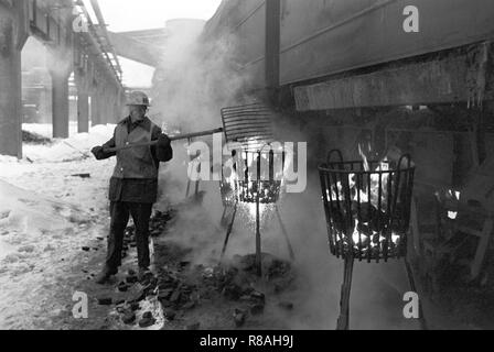 Au bunker du charbon de la brown coal power plant Vetschau dans l'ex-RDA sur Cottbus district 01.01.1979 soi-disant escadrons donnante dawith occupé l'exposition de la gelée dans les wagons de chemin de fer et de fonte charbon brut à la combustion du coke des paniers. L'heure de la fin de l'année 1978/1979 est entré dans l'histoire de la RDA comme 'Disaster' d'hiver. En quelques heures, les températures ont chuté de doux 5 à moins 20 degrés, avec des chutes de neige importantes perturbant le trafic et de grandes parties de l'économie. Le givre s'arrêta les courroies de transport et laisser le gel du charbon dans les wagons. Photo : Erich Schutt/dpa image centrale Banque D'Images