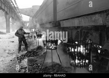 Au bunker du charbon de la brown coal power plant Vetschau dans l'ex-RDA sur Cottbus district 01.01.1979 soi-disant escadrons donnante dawith occupé l'exposition de la gelée dans les wagons de chemin de fer et de fonte charbon brut à la combustion du coke des paniers. L'heure de la fin de l'année 1978/1979 est entré dans l'histoire de la RDA comme 'Disaster' d'hiver. En quelques heures, les températures ont chuté de doux 5 à moins 20 degrés, avec des chutes de neige importantes perturbant le trafic et de grandes parties de l'économie. Le givre s'arrêta les courroies de transport et laisser le gel du charbon dans les wagons. Photo : Erich Schutt/dpa image centrale Banque D'Images