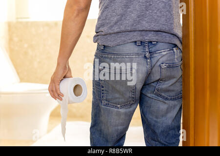 L'homme souffre de diarrhée tenant le rouleau de papier toilettes rendez-toilettes Banque D'Images