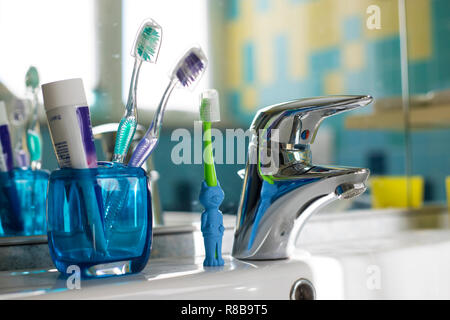 Brosses à dents de la famille dans la salle de bains, avec deux normales et une brosse à dents enfants en forme d'animaux Banque D'Images