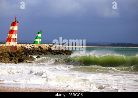 Vagues se brisant sur la plage en face de l'ighthouses & green du lred dans Lagos, Portugal. Banque D'Images