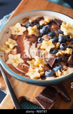 Smoothie banane sain bol avec noix de chocolat aux bleuets Banque D'Images