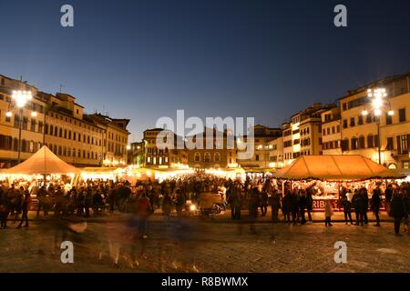 Florence, en décembre 2018 : Des lumières scintillantes au marché de Noël avec les touristes occupés à faire du shopping dans le centre de Florence, près de la Basilique de Santa Cro Banque D'Images