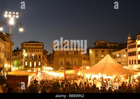 Florence, en décembre 2018 : Des lumières scintillantes au marché de Noël avec les touristes occupés à faire du shopping dans le centre de Florence, près de la Basilique de Santa Cro Banque D'Images