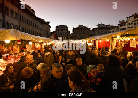 Florence, en décembre 2018 : Des lumières scintillantes au marché de Noël avec les touristes occupés à faire du shopping dans le centre de Florence, près de la Basilique de Santa Cro Banque D'Images