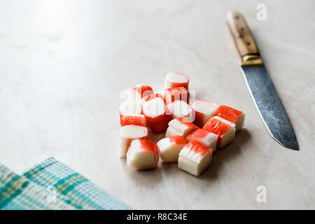 Fabricants de bâtons de crabe Surimi en tranches sur surface en marbre. Prêt à manger. Le fast food. Banque D'Images