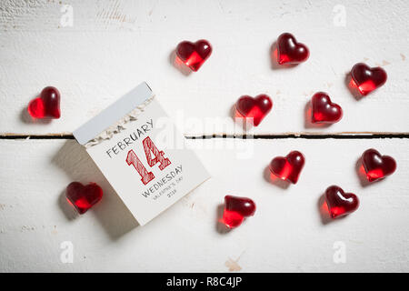 Calendrier de découpe avec 14 février sur le dessus, entouré de coeurs sur une surface en bois Banque D'Images