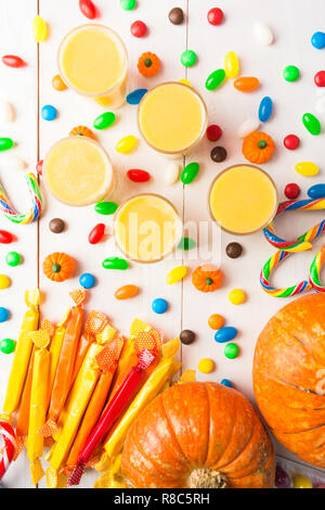 Vue de dessus de table de bonbons sweet halloween citrouille et sur table en bois blanc smoothie Banque D'Images