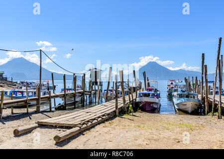 Panajachel, Lac Atitlan, Guatemala - 12 novembre 2018 : pour les bateaux jetées à la tête des villages au bord du lac avec volcan Toliman et volcan San Pedro derrière. Banque D'Images